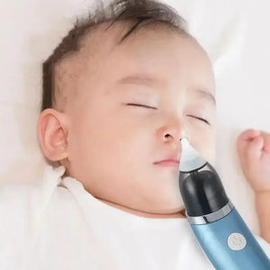 Baby lying down with electric nasal aspirator cleaning nose