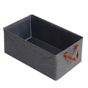 Rectangular gray fabric storage bin with brown handles, open and empty, on white background.