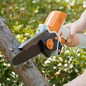Handheld mini chainsaw cutting tree branch outdoors, cordless electric pruning tool