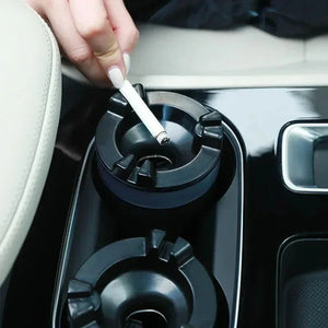 Hand holding cigarette over black car cup holder ashtray in vehicle interior