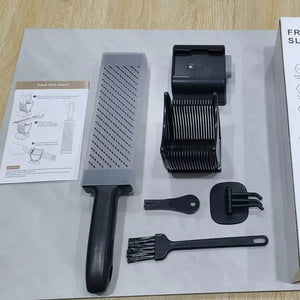 Kitchen mandoline slicer set with stainless steel blade, safety holder, brush, and instructions on a table.