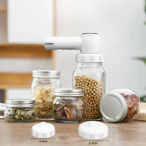 Vacuum sealer machine on glass jars with herbs and beans, kitchen food storage lids