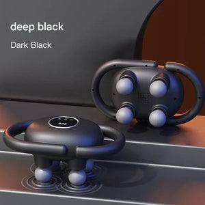Deep black handheld electric massager with four massage nodes on modern surface