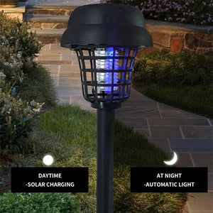 Outdoor solar-powered bug zapper garden light on stone pathway at night, automatic lighting
