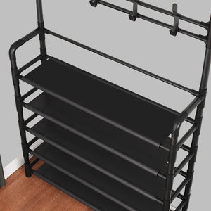 Black metal storage rack with five shelves and hooks, against a gray wall and wood floor