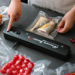 Person using a vacuum sealer machine to package fish and cherry tomatoes in vacuum bags.