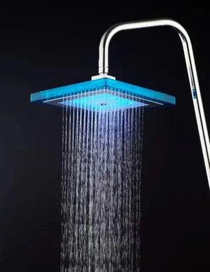 Modern square LED rainfall shower head with blue light, chrome finish, black background