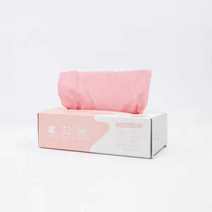 Pink removable microfiber cleaning rag in white dispenser box on white background