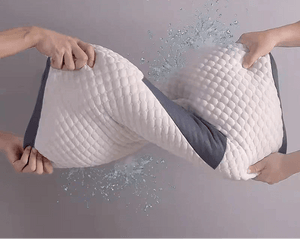 Hands twisting a water-resistant memory foam pillow with splash effect, washable cover