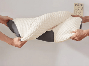 Hands stretching a memory foam pillow with textured cover in a minimalist room