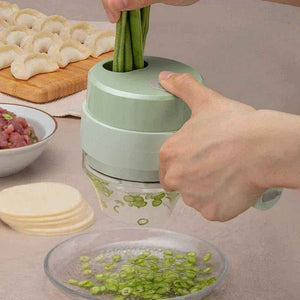 Hand using handheld rechargeable chopper to slice green beans, dumplings and ingredients nearby