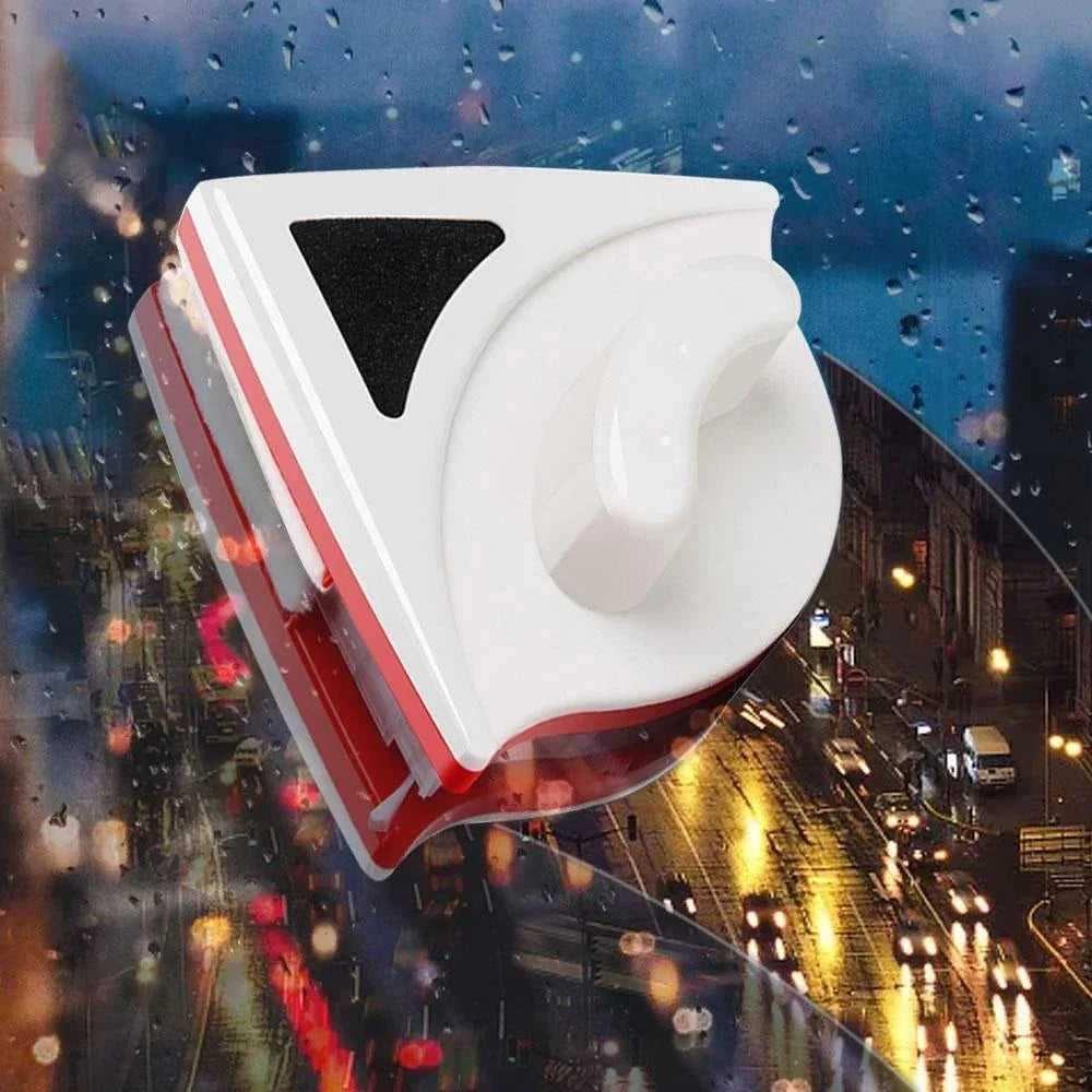 Magnetic window cleaner tool on rainy, city-lit glass surface at night