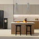 Modern kitchen with island, black refrigerator, bar stools, and sleek cabinets