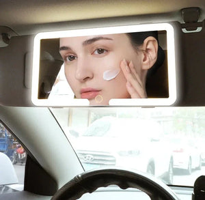 LED car visor vanity mirror with woman applying cream on her face