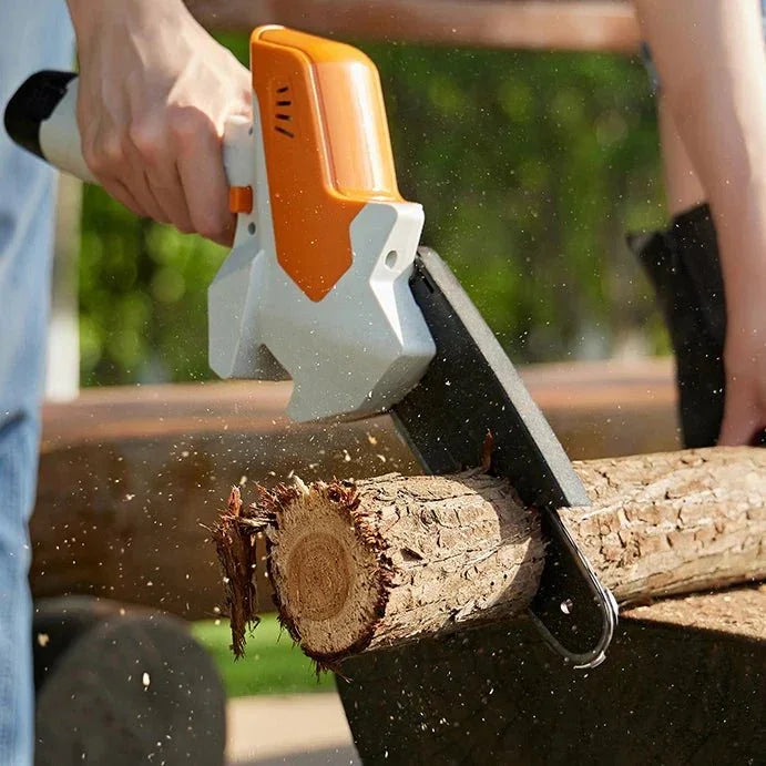 Handheld mini chainsaw cutting a wooden log outdoors, showing wood chips in motion