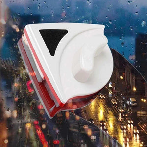 Magnetic window cleaner tool on rainy, city-lit glass surface at night